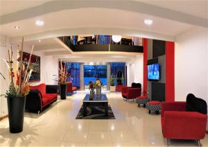 a living room with red couches and a table at Hosteria Aguaribay in Mina Clavero