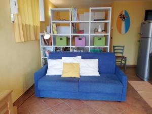 divano blu con due cuscini in una camera di Ariadimare guest house a Finale Ligure