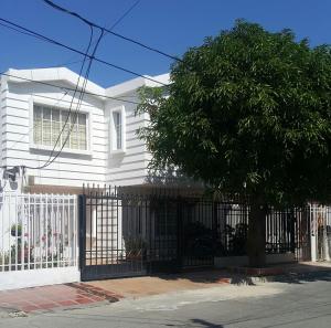 una casa blanca con una puerta y un árbol en Habitación Privada 10 min de la playa, entrada independiente., en Santa Marta