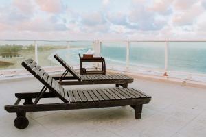 a bench sitting on top of a balcony overlooking the ocean at Casa beira mar na Praia da Redinha by Qavi in Natal