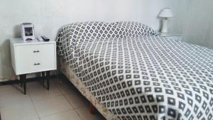1 cama con edredón blanco y negro en un dormitorio en San Bernardo a la vuelta del mar en San Bernardo