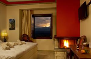 a bedroom with a bed with a fireplace and a window at Hotel Rodovoli in Konitsa