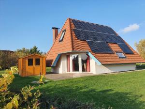 ein Haus mit Sonnenkollektoren auf dem Dach in der Unterkunft Ferienhaus Klapötke in Dorum Neufeld