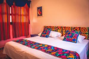 a bed room with a white bedspread and pillows at Casa Oaxaca in Santa Cruz Huatulco
