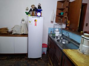 a kitchen with a white refrigerator and a sink at Sítio Kanisfluh in Treze Tílias