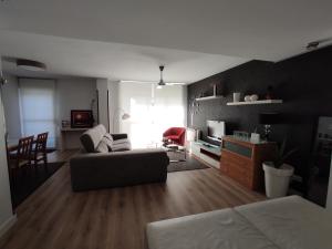 een woonkamer met een bank, een tafel en een tv bij Chalet en Cabezón VUT 47-208 in Cabezón de Pisuerga