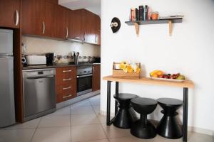a kitchen with a table and some black stools at Casa Pombalinho, an old Fisherman Cottage in Fuzeta