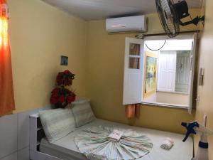 um pequeno quarto com uma cama e uma janela em Pousada Tia Tita em Morro de São Paulo