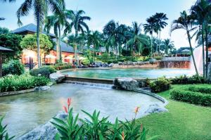 a pool at a resort with a waterfall and palm trees at Cyberview Resort & Spa in Cyberjaya