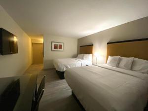 una camera d'albergo con due letti e una televisione di University Inn of Carbondale a Carbondale