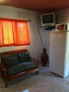 a living room with a couch and a refrigerator at Cabañas y Posada La Vertiente in Los Reartes