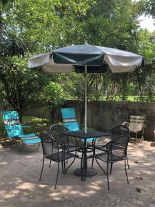 a table and chairs with an umbrella on a patio at Casa del Reto&ntilde;o in Guadalajara