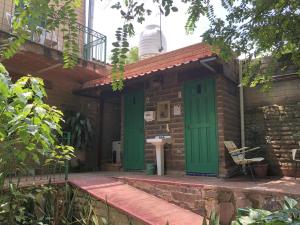 a brick house with green doors and a table at Casa del Reto&ntilde;o in Guadalajara