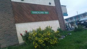 a sign on the side of a building with yellow flowers at RANCHLAND Inn in Nanton