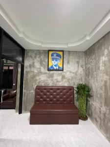 a couch in a waiting room with a picture on the wall at Hugpua Hotel in Nan
