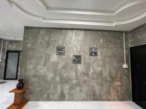 a room with a wall with pictures on it at Hugpua Hotel in Nan