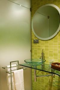 ein Badezimmer mit einem Glaswaschbecken und einem Spiegel in der Unterkunft Hospedium Apartamentos Cañitas Maite Familiar in Casas-Ibáñez