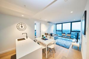 Il comprend une cuisine et un salon offrant une vue sur l'océan. dans l'établissement Mega Style Apartments Victoria One, à Melbourne