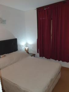 a bedroom with two beds and a red curtain at Miramar Panorámico in Miramar +17 photos