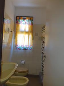 baño con lavabo y aseo y ventana en Miramar Panorámico en Miramar