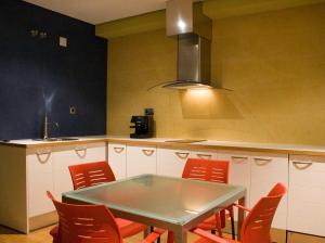 cocina con mesa y sillas rojas en Hospedium Apartamentos Cañitas Maite Familiar, en Casas Ibáñez