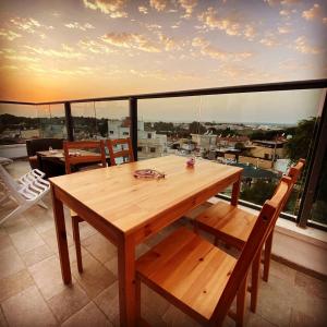 a wooden table and chairs on a balcony with a view at comft suite Nahariyya in Nahariyya