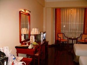 a hotel room with a bed and a desk with a mirror at Sunny C Hotel in Hue