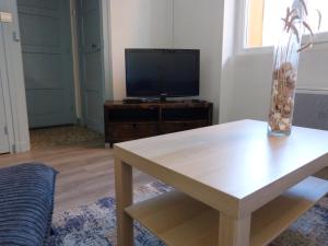 een woonkamer met een tafel en een televisie bij Appartement Topaze Bourg d'Oisans in Le Bourg-dʼOisans