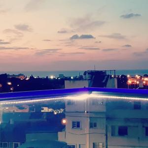 a swimming pool with a view of a city at night at Nice suite Nahariyya in Nahariyya