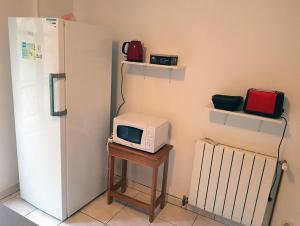 a microwave sitting on a table next to a refrigerator at Le Logis Autonome, chambre d'hôtes in Saint-Sernin-du-Plain