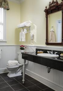 a bathroom with a toilet and a sink and a mirror at Saratoga Arms in Saratoga Springs