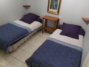 two beds in a small room with a table at Gîte Santenay les Bains in Saint-Sernin-du-Plain