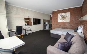 a living room filled with furniture and a tv at Albury Townhouse Motel in Albury