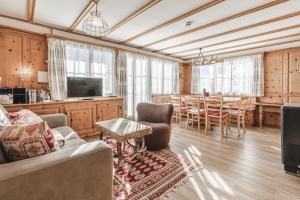 ein Wohnzimmer mit einem Sofa und einem Tisch in der Unterkunft Chalet Sunna Höckli - Pistennah und Ruhig mit Panoramablick in Arosa