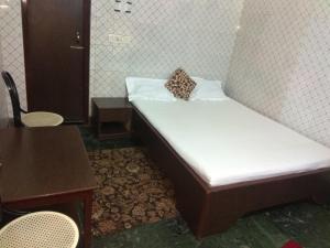 Hotel Prince في غاواهاتي: سرير صغير ومخدة عليه في غرفة