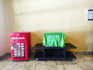 eine grüne Tasche, die auf einem Tisch neben einer roten Schachtel sitzt. in der Unterkunft CONDOMINIUM LIPPO CARITA, Lantai Dasar - OFFICIAL in Carita