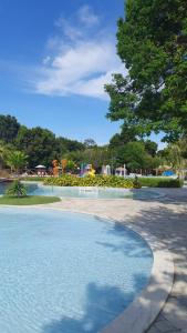 uma piscina de água com uma árvore ao fundo em Residencial Iloa na Barra de São Miguel
