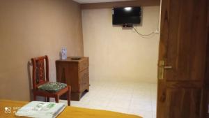 - une chambre avec une commode et une télévision murale dans l'établissement Hotel Nur Cahaya - Syariah, à Probolinggo