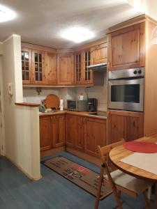 a kitchen with wooden cabinets and a table and a dining room at Kossuth Apartman in Budapest