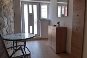 a kitchen with a glass table and a counter at Apartmant Angel Wings in Omiš