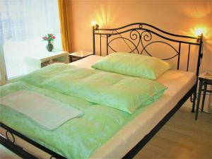 un letto con lenzuola e cuscini verdi in una camera da letto di soukromý pokoj a Praga
