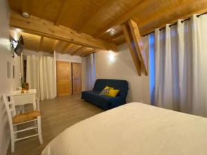 a bedroom with a bed and a blue couch at Le Cocon de Curson chambre d'hôtes in Chanos-Curson