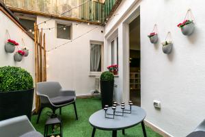 a patio with a table and chairs and plants at BOUTIQUE APARTMENTS COLLECTION-GENIO RIBELLE in Sassari