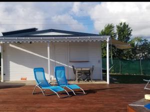 two blue chairs on a patio with a picnic table at Séjournez au coeur des Tropiques Bungalow 2 chambres avec Piscine proche de la mer in Sainte-Anne