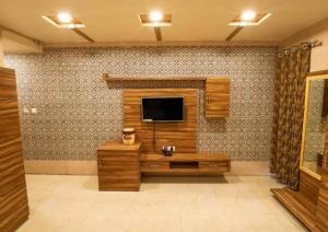 a living room with a television on a wall at Hotel Sundaram 5 Minutes Distance from Dargah in Ajmer