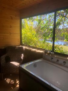 eine Badewanne in einem Raum mit Fenster in der Unterkunft Clover Cottage Country Retreat in Manjimup