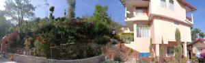 a large building with a garden next to a house at SAI´S GRACE in Kalimpong +22 photos