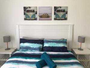um quarto com uma cama com três fotografias na parede em 20 Key Largo em Amanzimtoti