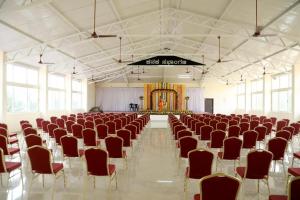 una grande stanza con file di sedie e un palco di Fortune Village Hotel a Kundapur