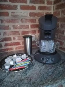 een koffiezetapparaat op een aanrecht naast een bord bij Vakantiewoning Upstairzzz in Kortessem